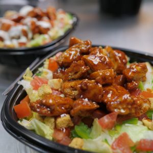 Two bowls of bbq chicken salad on a counter.