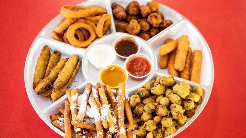 An assortment of 8 Wings & Burger Combo on a platter with dipping sauces.