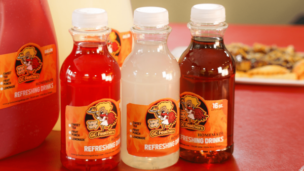 Three bottles of homemade refreshing drinks with distinct colors, labeled and presented on a table.