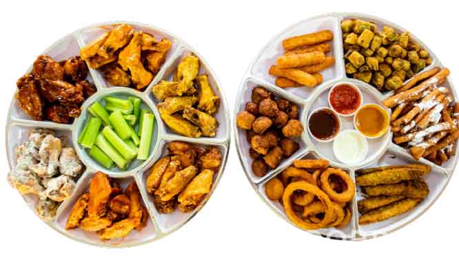 Two platters of assorted snacks and appetizers, including chicken wings, celery sticks, and various fried foods with dipping sauces.