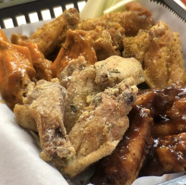 A variety of seasoned and sauced 30 Wings Combo on a tray.