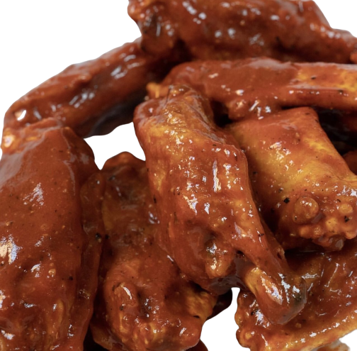 A pile of buffalo wings coated in a glossy, reddish-brown sauce.