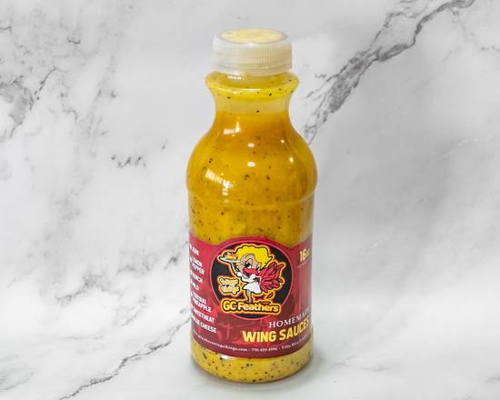 A bottle of ggefeathers wing sauce on a marble background.