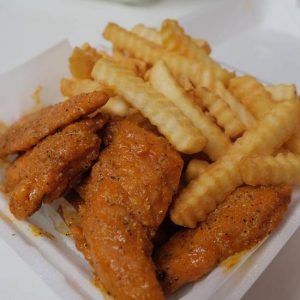 A serving of buffalo wings accompanied by crinkle-cut fries.