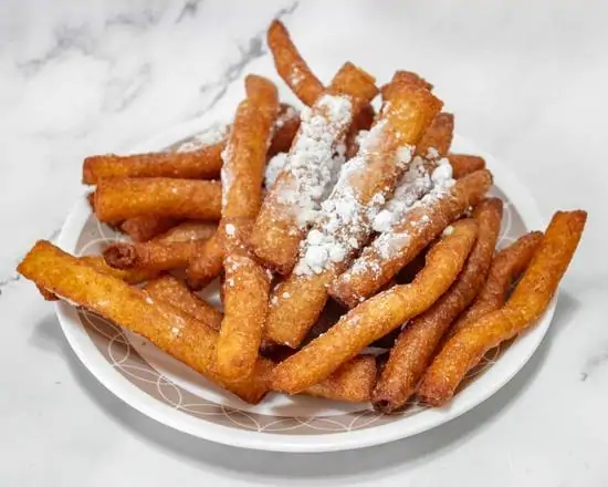 A plate of churros dusted with powdered sugar.