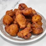 A plate of fried golden-brown fritters.